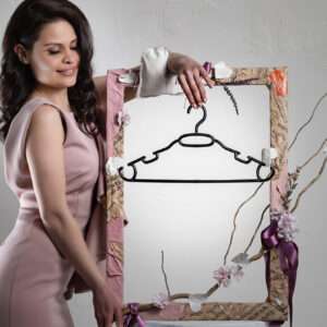 A beautiful brunette model wearing pink dress and showing a beautiful designed clothes/coad hanger.Photo cover of the blogpost about: How Embracing Beautiful Coat Hangers Can Change Your Life?